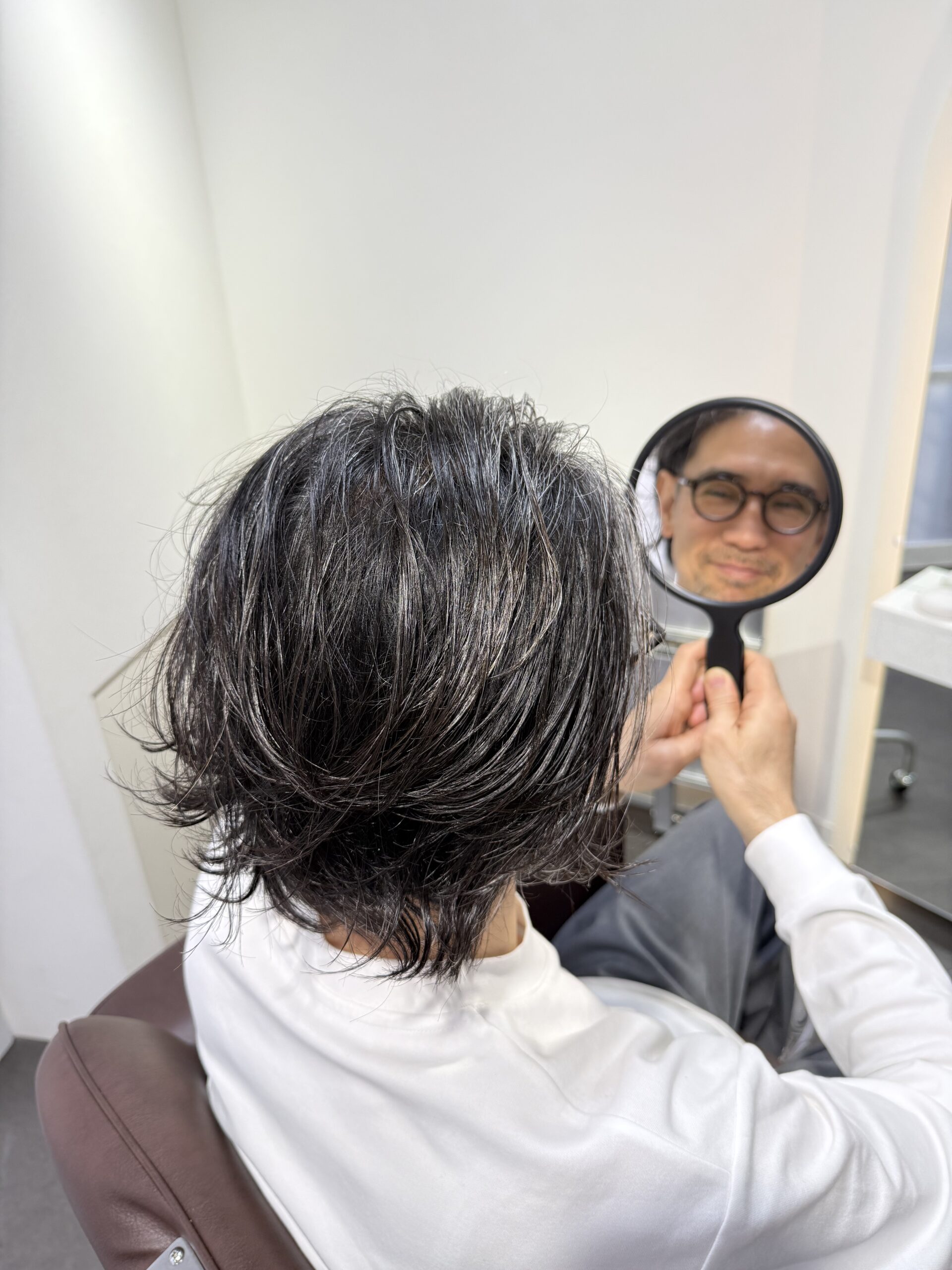施術後に鏡を見るお客様